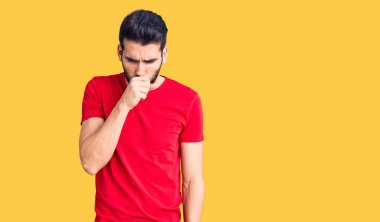 Sakallı, sıradan bir tişört giyen, kendini kötü hisseden ve soğuk algınlığı veya bronşitin belirtisi olarak öksüren genç yakışıklı bir adam. sağlık hizmeti kavramı. 