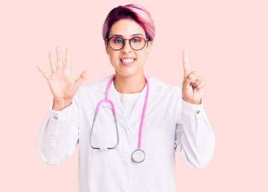 Pembe saçlı, doktor üniforması giyen genç ve güzel bir kadın altı numaralı parmaklarını gösterip işaret ederken kendinden emin ve mutlu bir şekilde gülümsüyor.. 