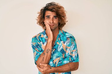 Yazlık tişört giyen genç İspanyol adam kollarını kavuşturarak depresyondan sıkılmış ve yorgun görünüyor.. 