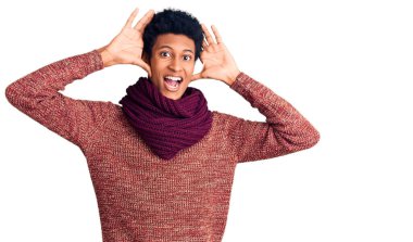 Genç Afro-Amerikan adam, günlük kışlık süveter ve atkı giyip neşeli gülümseyen, elleriyle dikizleyerek yüzünü gösteren bir yuhalama oynuyor. Şaşırdım ve çıktım. 