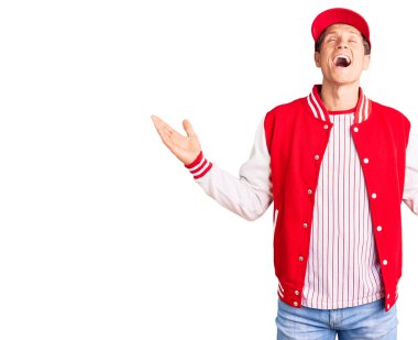 Beyzbol üniforması giyen yakışıklı genç adam, başarı için deli ve çılgınlığı kutlarken kollarını kaldırmış ve gözlerini kapatmış heyecanlı çığlıklar atıyordu. Kazanan konsept 