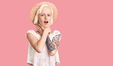 Dövmeli, yaz şapkalı, bağıran ve boğulan genç sarışın kadın. Çünkü acı verici bir şekilde boğuldu. Sağlık problemi. Boğulma ve intihar konsepti. 