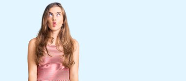 Gündelik kıyafetler giyen, dudaklarıyla balık suratı yapan, çılgın ve komik bir jest yapan güzel beyaz bir kadın. Komik ifade. 