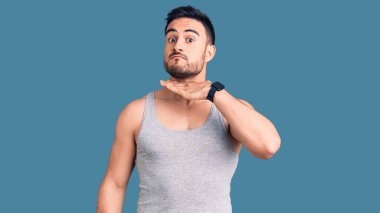 Mayo ve kolsuz tişört giyen, boğazını bıçak niyetine kesen genç yakışıklı bir adam, saldırganlığı şiddetli bir şiddetle tehdit ediyor. 