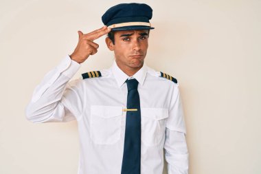 İspanyol asıllı genç adam, uçak pilotu üniforması giyiyor. Kendini vuruyor ve öldürüyor. Silah gibi el ve parmakları işaret ediyor.. 