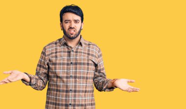 Gündelik giysiler giyen genç İspanyol adam habersiz ve kolları açık, hiçbir fikri yok.. 