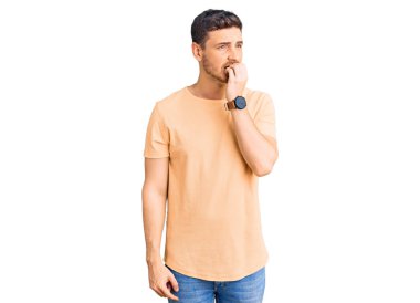 Ayılı yakışıklı, sıradan sarı tişörtlü, gergin ve ağzı tırnak yiyen elleri olan bir delikanlı. anksiyete. 