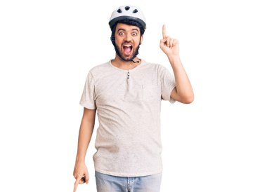 Bisiklet kaskı takan genç bir İspanyol başarılı bir fikir işaret ediyor. Heyecanlı ve mutlu. Bir numara.. 