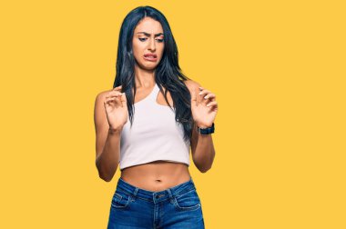 Güzel İspanyol kadın gündelik giysiler giyiyor, tiksindirici bir ifade takınıyor, tiksindirici bir yüz ifadesi takınıyor ve tiksindirici bir ifade takınıyor.. 