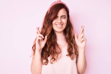 Genç ve güzel bir kadın, günlük kıyafetler giyip umut ve gözlerin kapalı gülümseyerek el sallıyor. Şans ve batıl inançlar. 