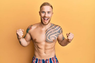 Mayo giyen genç, beyaz bir adam kollarını kaldırıp, gözleri açık bir şekilde başarıyı kutluyor. Kazanan konsept. 