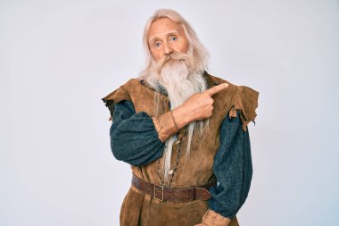 Gri saçlı, uzun sakallı, Viking kostümü giyen yaşlı yaşlı bir adam. Elleri yana dönük, ciddi ve sakin bir yüz ifadesi sergiliyor. 