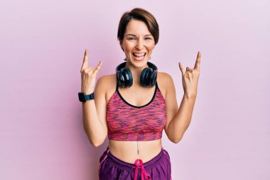 Kısa saçlı, spor giyimli, kulaklık takan, çılgın bir ifadeyle bağıran, elleri havada rock sembolü yapan esmer bir kadın. Müzik yıldızı. ağır kavram. 