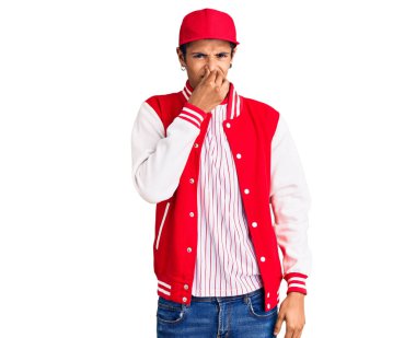 Beyzbol üniforması giyen genç Afro-Amerikan bir adam pis ve iğrenç bir koku alıyor, dayanılmaz bir koku, nefesini burnu havada tutuyor. Kötü kokuyor. 