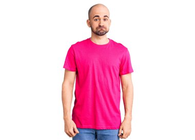 Gündelik tişört giyen genç yakışıklı adam komik yüzlü yanakları şişiriyor. Havayla şişmiş ağız, çılgın bir ifade.. 