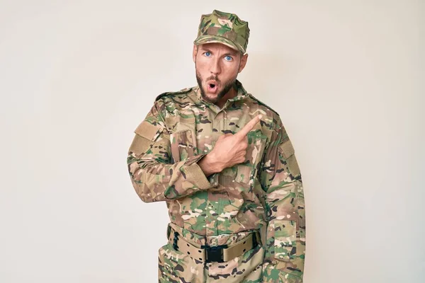 Joven Hombre Caucásico Vistiendo Camuflaje Ejército Uniforme Sorprendido Señalando Con — Foto de Stock