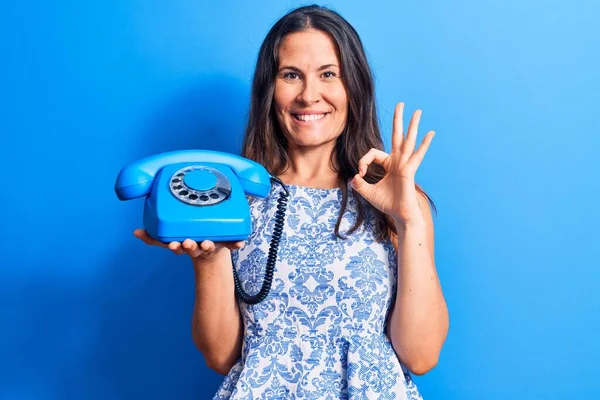 Jovem Bela Mulher Morena Segurando Telefone Vintage Sobre Fundo Azul — Fotografia de Stock