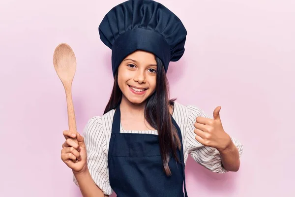 美しい子供の女の子身に着けている炊飯器制服笑顔と正 親指アップ行う優れた承認サイン — ストック写真