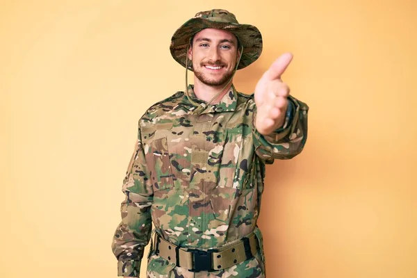 カモフラージュ軍の制服を着た若い白人男性が挨拶や歓迎として握手を提供する優しい笑顔 成功したビジネス — ストック写真