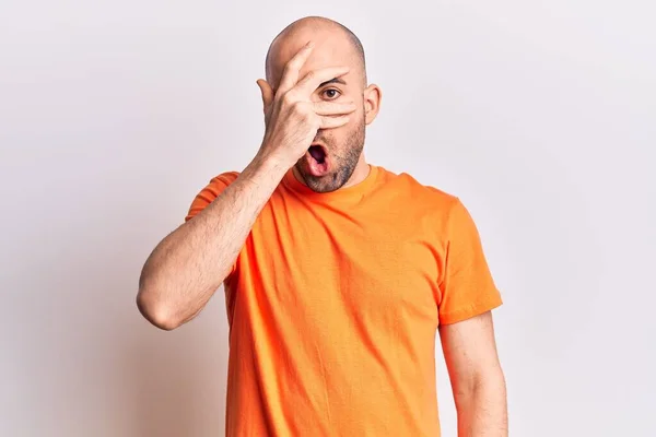 Jovem Careca Bonito Vestindo Camiseta Casual Espreitando Choque Cobrindo Rosto — Fotografia de Stock