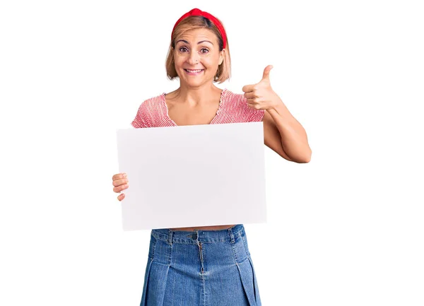 Mujer Rubia Joven Sosteniendo Banner Vacío Blanco Sonriendo Feliz Positivo —  Fotos de Stock