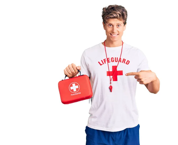 Mladý Pohledný Muž Sobě Plavčík Tričko Drží První Pomoc Kit — Stock fotografie