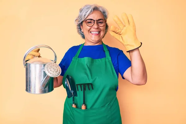 Ältere Hispanische Grauhaarige Frau Mit Gärtnerschürze Und Handschuhen Die Gießkanne — Stockfoto