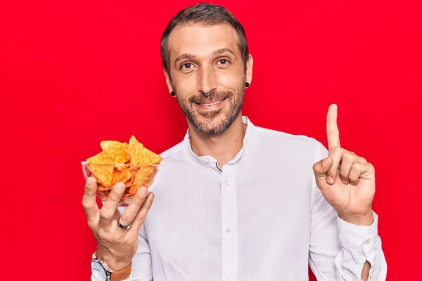 Fiatal Jóképű Férfi Nachos Chipsszel Kezében Mosolygott Egy Ötlettel Vagy — Stock Fotó