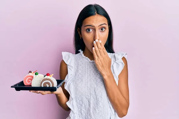 Young Brunette Woman Holding Cake Sweets Covering Mouth Hand Shocked — Stock Photo, Image