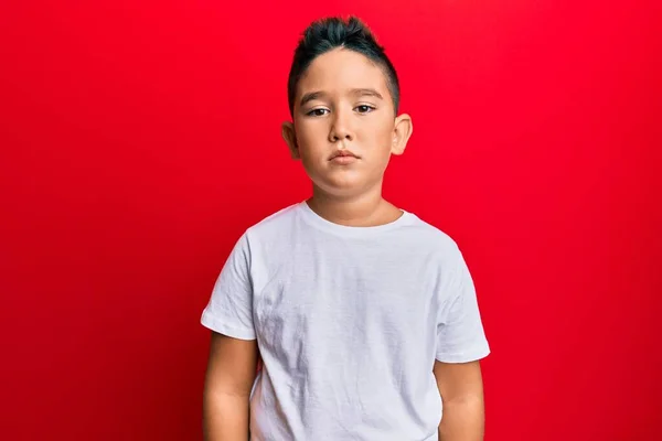顔に真剣な表情のカジュアルな白いTシャツを着た小さな男の子のヒスパニック系の子供 カメラを見ているだけで — ストック写真