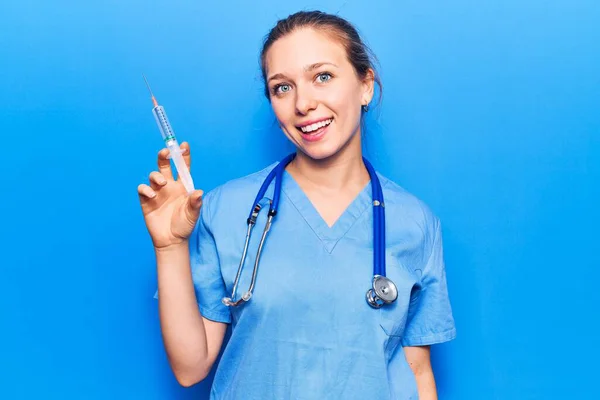 Mujer Rubia Joven Vistiendo Uniforme Médico Sosteniendo Jeringa Con Aspecto —  Fotos de Stock