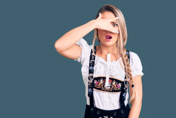 Joven Hermosa Mujer Rubia Con Vestido Oktoberfest Asomándose Shock Cubriendo — Foto de Stock