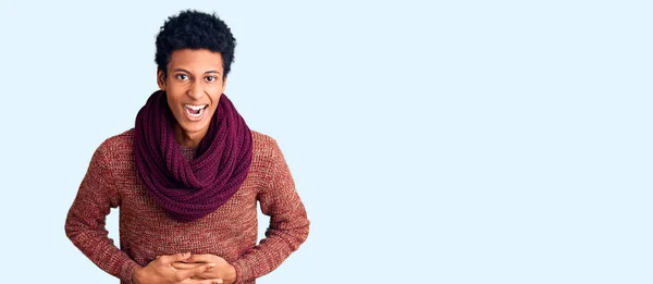 若いアフリカ系アメリカ人男性を身に着けているカジュアル冬のセーターとスカーフ笑顔と笑いハードアウト大声でなぜなら面白いクレイジー冗談で手で体 — ストック写真