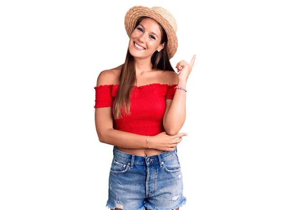 Молодая Красивая Латиноамериканка Летней Шляпе Улыбается Счастливо Указывая Рукой Пальцем — стоковое фото