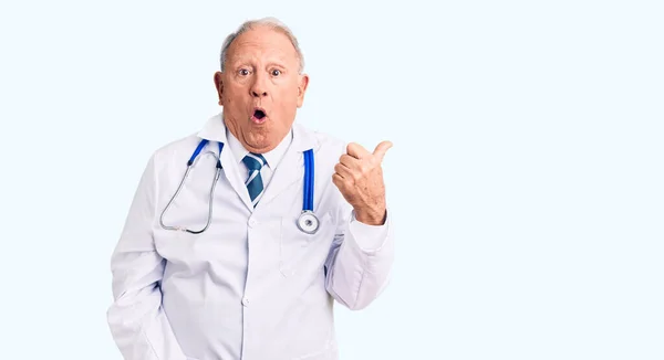 Senior Knappe Grijsharige Man Draagt Doktersjas Stethoscoop Verrast Wijzend Met — Stockfoto