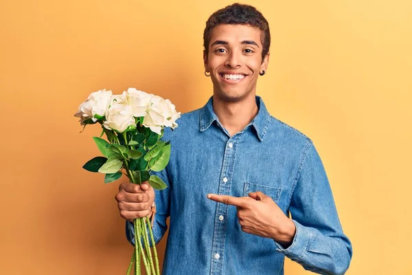Ung Afrikansk Amercian Man Håller Blommor Ler Glad Pekar Med — Stockfoto