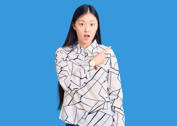 Jonge Mooie Chinese Vrouw Draagt Casual Shirt Verrast Wijzend Met — Stockfoto