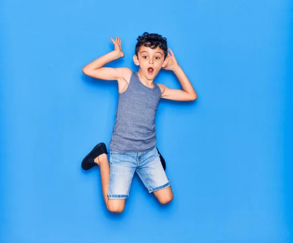 Adorable Niño Con Ropa Casual Saltando Sobre Fondo Azul Aislado — Foto de Stock