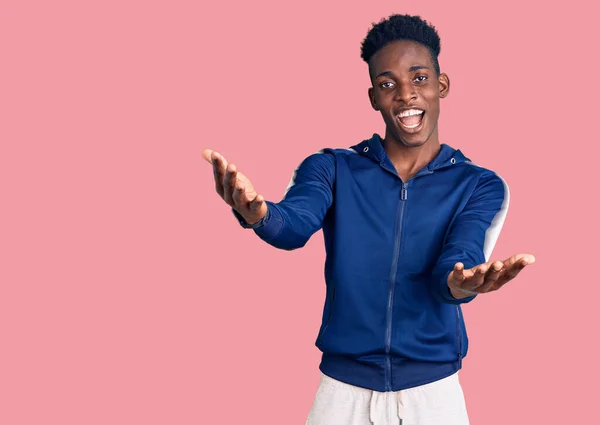 Joven Hombre Afroamericano Vistiendo Ropa Deportiva Sonriente Alegre Ofreciendo Manos — Foto de Stock