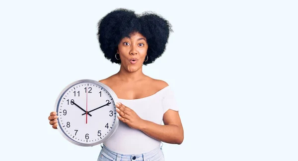 Young African American Girl Holding Big Clock Scared Amazed Open — Stock Photo, Image