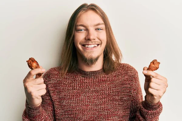 Knappe Blanke Man Met Lang Haar Die Kippenvleugels Eet Glimlacht — Stockfoto