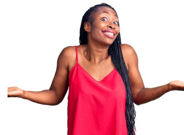 Sıradan kıyafetler giyen, kafası karışmış, elleri ve kolları havada genç bir Afrikalı Amerikalı kadın. şüphe kavramı. 