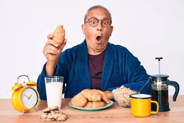 Homem Bonito Sênior Com Cabelos Grisalhos Sentado Mesa Comendo Croissant — Fotografia de Stock
