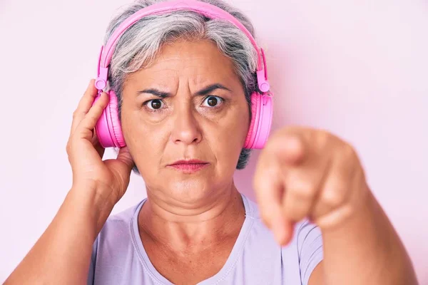 Mujer Hispana Mayor Escuchando Música Usando Auriculares Apuntando Con Dedo —  Fotos de Stock