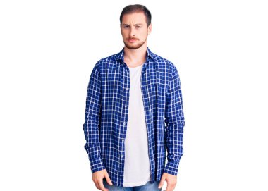 Gündelik kıyafetler giyen yakışıklı beyaz bir adam şüpheci ve gergin, sorun yüzünden surat asıyor. negatif kişi. 