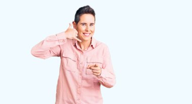 Kısa saçlı, günlük kıyafetler giyen, gülümseyen, telefonda konuşan ve seni işaret eden genç bir kadın. Ara beni.. 