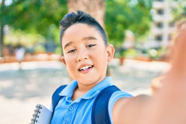 Sevimli öğrenci gülümseyerek kentin caddesindeki kameranın önünde selfie çekiyor..