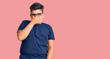 Günlük kıyafetler giyen ve gözlük takan küçük çocuk pis ve iğrenç bir koku alıyor. Nefesini burnunda tutuyor. Kötü kokuyor. 