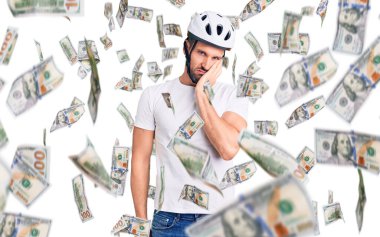 Bisiklet kaskı takan yakışıklı genç adam yorgun ve bunalımdan sıkılmış görünüyordu..