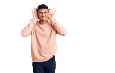 Gündelik giysiler giyen genç İspanyol adam iki elini de kulak hareketlerini duymaya çalışıyor. Dedikoduya meraklı. İşitme sorunu, sağır 